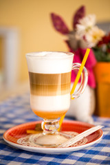 beautiful cappuccino, latte,coffee in a glass Cup on a checkered tablecloth