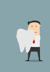 Businessman holding a large white tooth