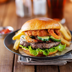 big burger close up with onion ring topping and bacon