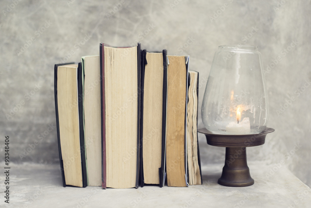 Poster different books and a candle on a table