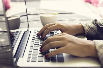 Typing girl with laptop and coffee
