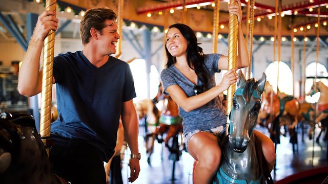 romantic couple riding carousel together