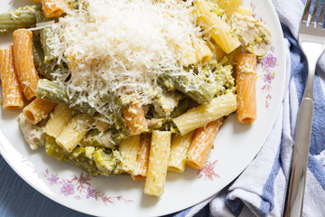 Chicken and broccoli with penne pasta, with garlic sauce and cheese. Closeup and top view.