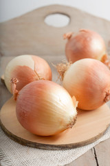 whole onions on wooden board