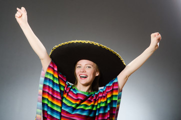 Girl in mexican vivid poncho against gray