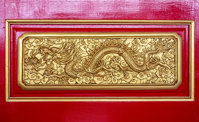 Golden Chinese dragon on red wood background