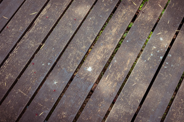 old wooden walkway with falling leaves in the morning of autumn