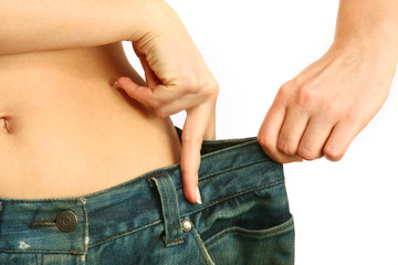 Fototapeta premium A slim woman is showing how much weight she lost