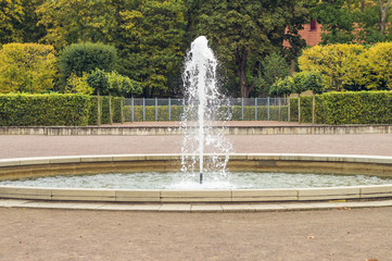 Circle fountain with colorful autumn trees on background