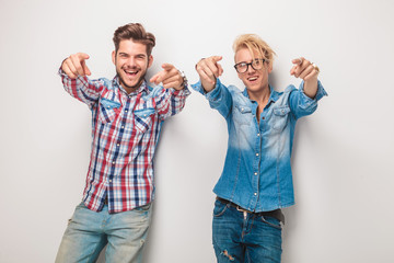 Fototapeta na wymiar two excited young casual men pointing fingers