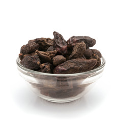 Front view of Organic Chebulic Myrobalan or Choti Harad (Terminalia chebula) in glass bowl isolated on white background.