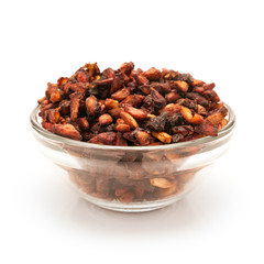 Front view of Organic Dried Pomegranate seeds (Punica granatum) in glass bowl isolated on white background.