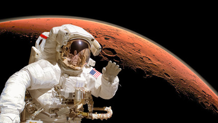 Close up of an astronaut in outer space, planet Mars in the background. Elements of the image are...