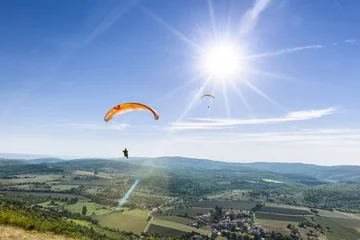 Poster Twee paragliders onder de stralen van een witte zon © LAFORET Aurélien