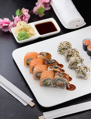 Sushi set with chopsticks and soy sauce over dark wooden background
