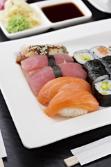 Sushi set with chopsticks and soy sauce over dark wooden background