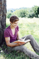 Young man is sitting and reading a book