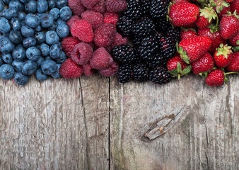 Different Fresh Berries on Wooden Background. Strawberries, Raspberries and Blueberries