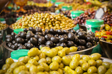 Olives at a market stall. A variety of types of olives. Green, black, Syrians and others.
