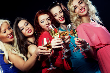 partying girls clinking flutes with sparkling wine
