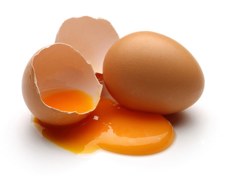Broken brown eggs isolated on white