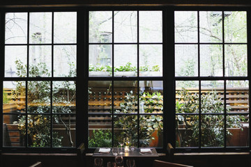 Interior view of a restaurant in Manhattan's West Village, window overlooking a garden.