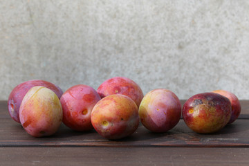 Some plums on the wood table.
