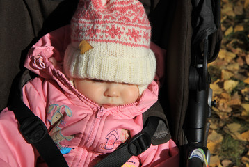 Sleeping baby girl in warm pink clothes