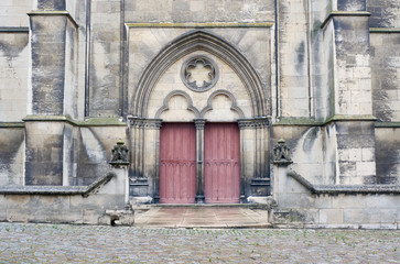 Stone portal and a wooden door to the medieval church Troyes, France.