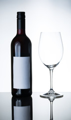 bottle of red wine and empty wine glass