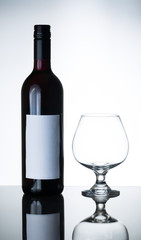 bottle of red wine and empty wine glass