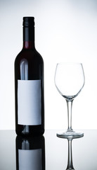 bottle of red wine and empty wine glass