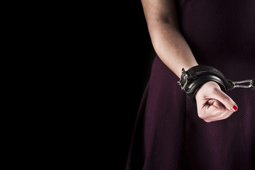 submissive woman wearing a purple dress in leather handcuffs on - 93382848