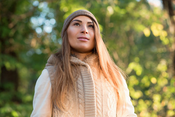 Beautiful woman in a knitted garment and cap in the park