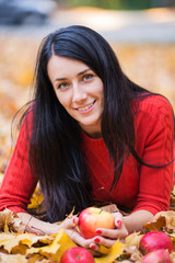 portrait of a girl in a red apple on the nature autumn