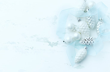 White and silver Christmas ornaments on painted wood