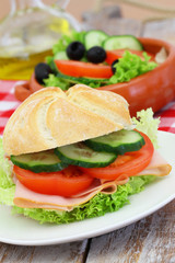 Healthy lunch consisting of ham roll and green salad
