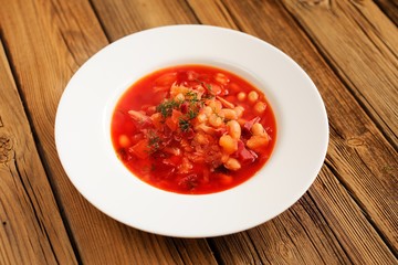 Portion of homemade Russian red beet soup borsch with bean, cabb