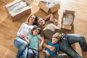 a family laying in their new flat with cardboard boxes