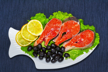 Trout with vegetables on a plate on a blue background