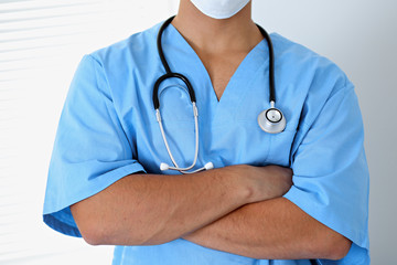 Portrait of unknown male surgeon doctor holding his stethoscope, crossed arms