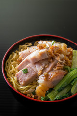 yellow noodle with crispy pork on black background