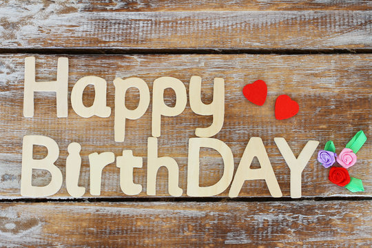 Happy birthday written with wooden letters on rustic wood
