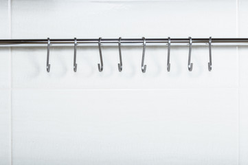 Metal hooks on a chromed tube.


