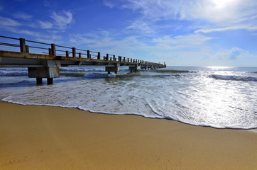 Fototapeta premium Weathered concrete breakwater with a rusty sheet pile and angled
