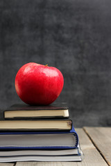 Notebook stack with apple and chalkboard