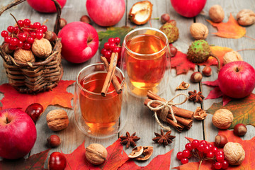 Autumn hot beverage in a glass with fruits and spices