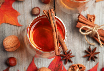 Fototapeta na wymiar Autumn hot beverage in a glass with fruits and spices