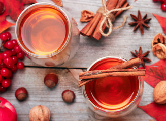 Autumn hot beverage in a glass with fruits and spices