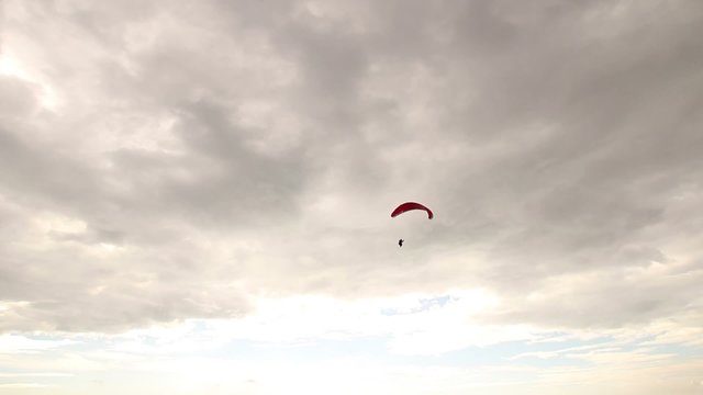 Paraglider flying on a panoramic spot with the sea in a cloudy day